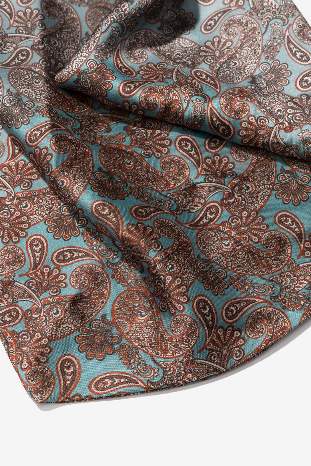 Bandana estampada paisley de Vilanova en tonos azul aguamarina y marrón con detalle decorativo de cuentas negras en los extremos.