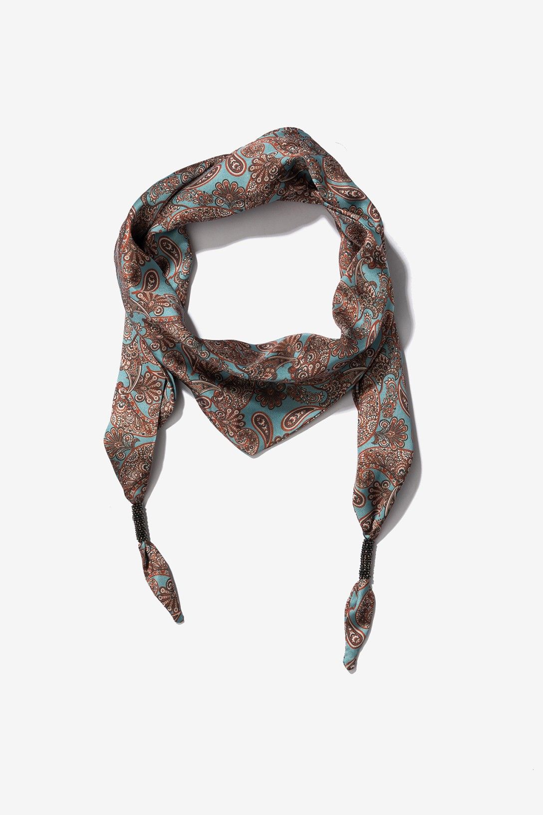 Bandana estampada paisley de Vilanova en tonos azul aguamarina y marrón con detalle decorativo de cuentas negras en los extremos.