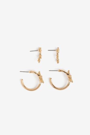 Pack de pendientes dorados Vilanova con diseño de estrellas de mar, compuesto por aros decorativos y pendientes trepadores.