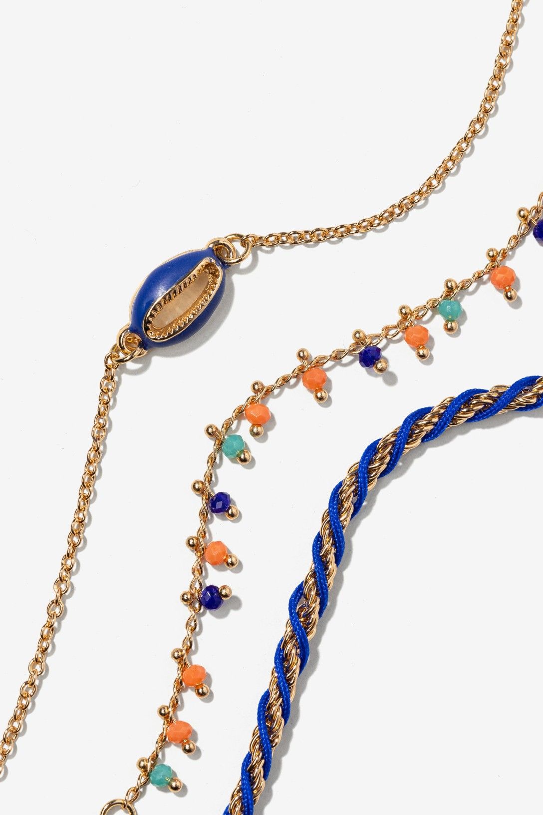 Pack de pulseras marineras Vilanova con concha azul, abalorios multicolor y pulsera trenzada en tonos azul y dorado.