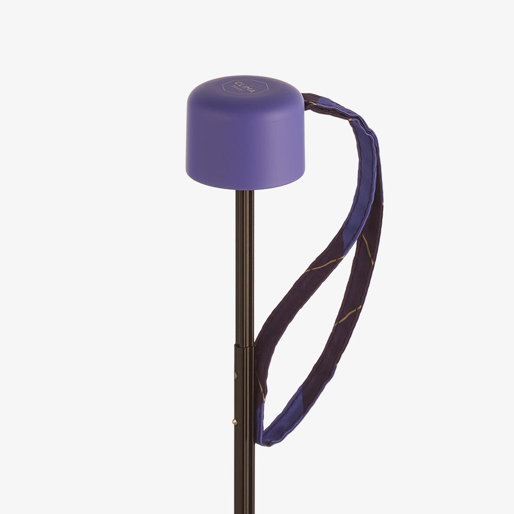 Paraguas plegable Clima con estampado de cuadros lila y morado e incluye estuche a juego para guardar y transportar cómodamente.