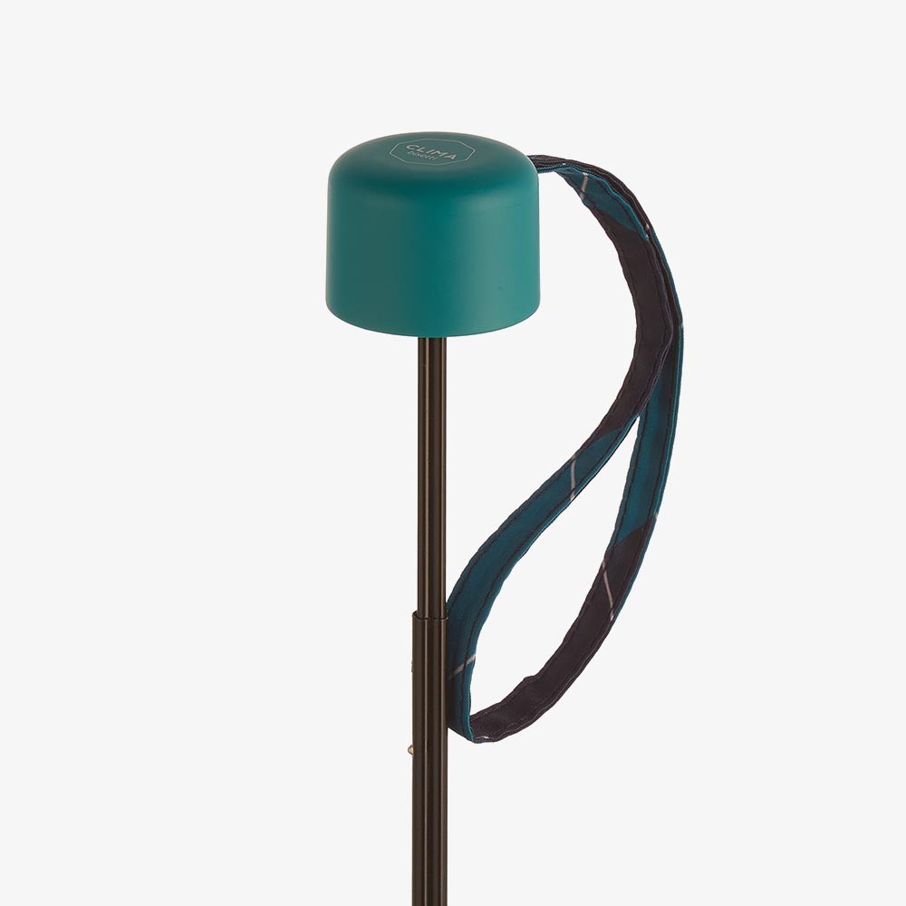 Paraguas plegable Clima con estampado geométrico en tonos verde azulado y azul marino, acompañado de estuche con cremallera a juego.