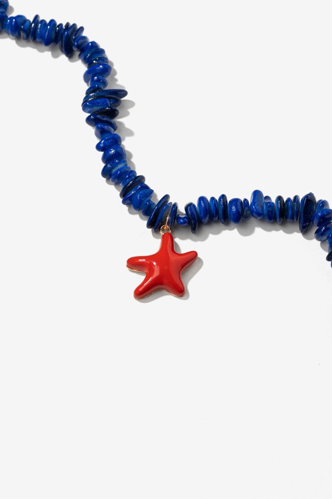 Pulsera tobillera Estrella Coral Vilanova con piezas de concha azul, colgante de estrella de mar coral y detalles dorados de inspiración mediterránea.