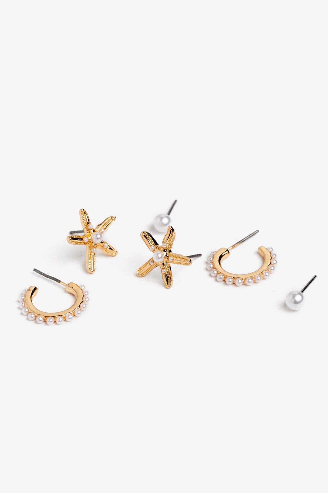 Set de tres pares de pendientes Vilanova con estrellas de mar, perlas y aros dorados de inspiración marina.