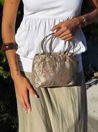 Bolso Eventos Anillas Kate De La Mur beige con asas metálicas plateadas.