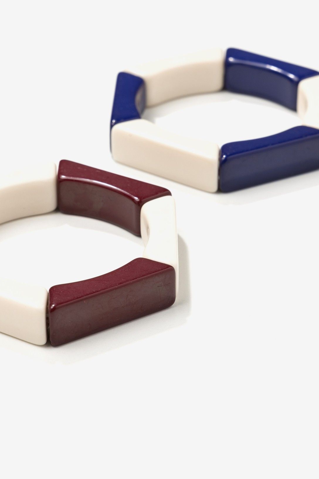Pack de Dos Pulseras Hexagonales Vilanova en acrílico color marfil con detalles en azul marino y burdeos.
