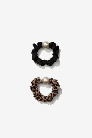 Pack Scrunchies con Cuentas Efecto Perla Vilanova formado por dos coleteros de tela, uno negro y otro con estampado animal print, con detalle decorativo de perla.